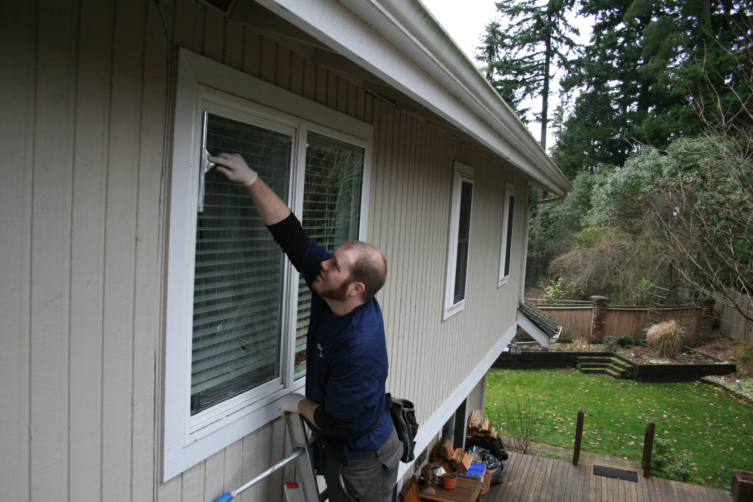Window Cleaning near Klahanie area a Chinook Services worker making this homes windows look new again
