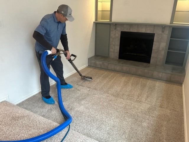 Cleaning carpets near a Seattle area home by Chinook Services. The worker makes effort to make the carpets look new again with steam and vacuum.
