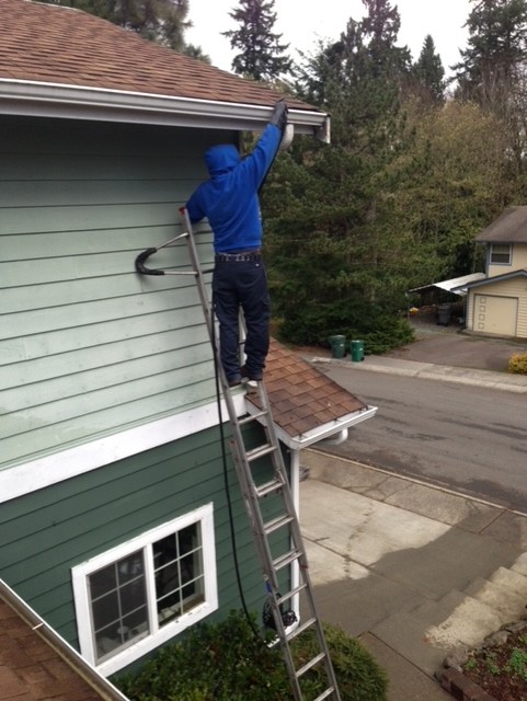 Cleaning Arlington gutters by hand. Performed by Chinook Services a local provider.