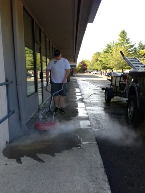 Seattle pressure washer worker cleaning concrete. Performed by Chinook Services local to Seattle, WA for over 20 years.