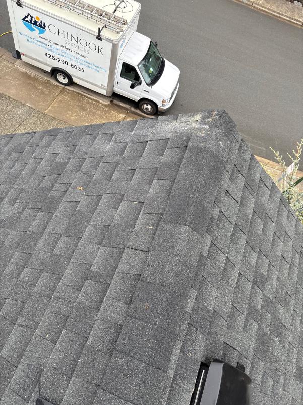 Peak of a roof with Chinook Services truck in driveway. Crew performed roof cleaning near Seattle, WA