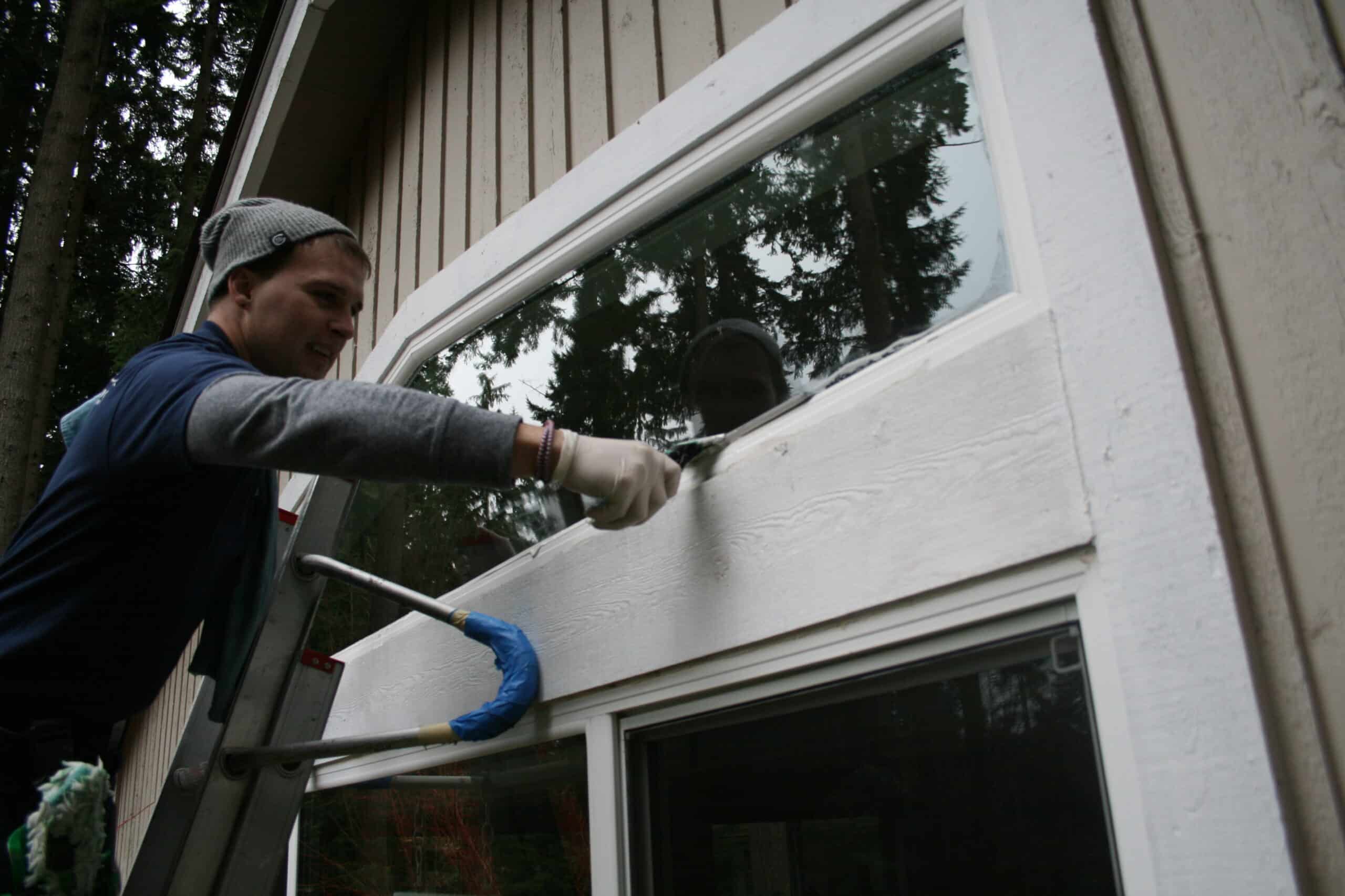 Cleaning upper window of a Bear Creek home