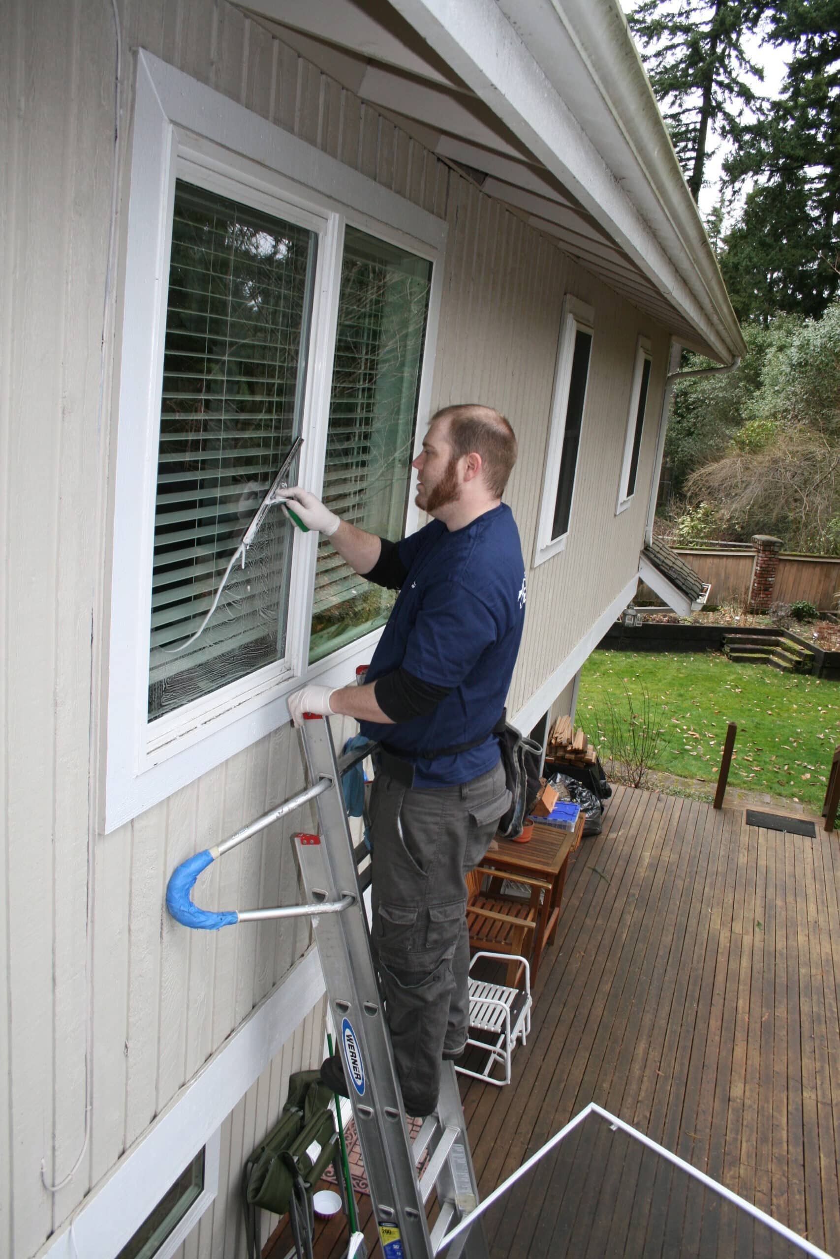 Cleaning window in Bothell, WA by hand from a ladder