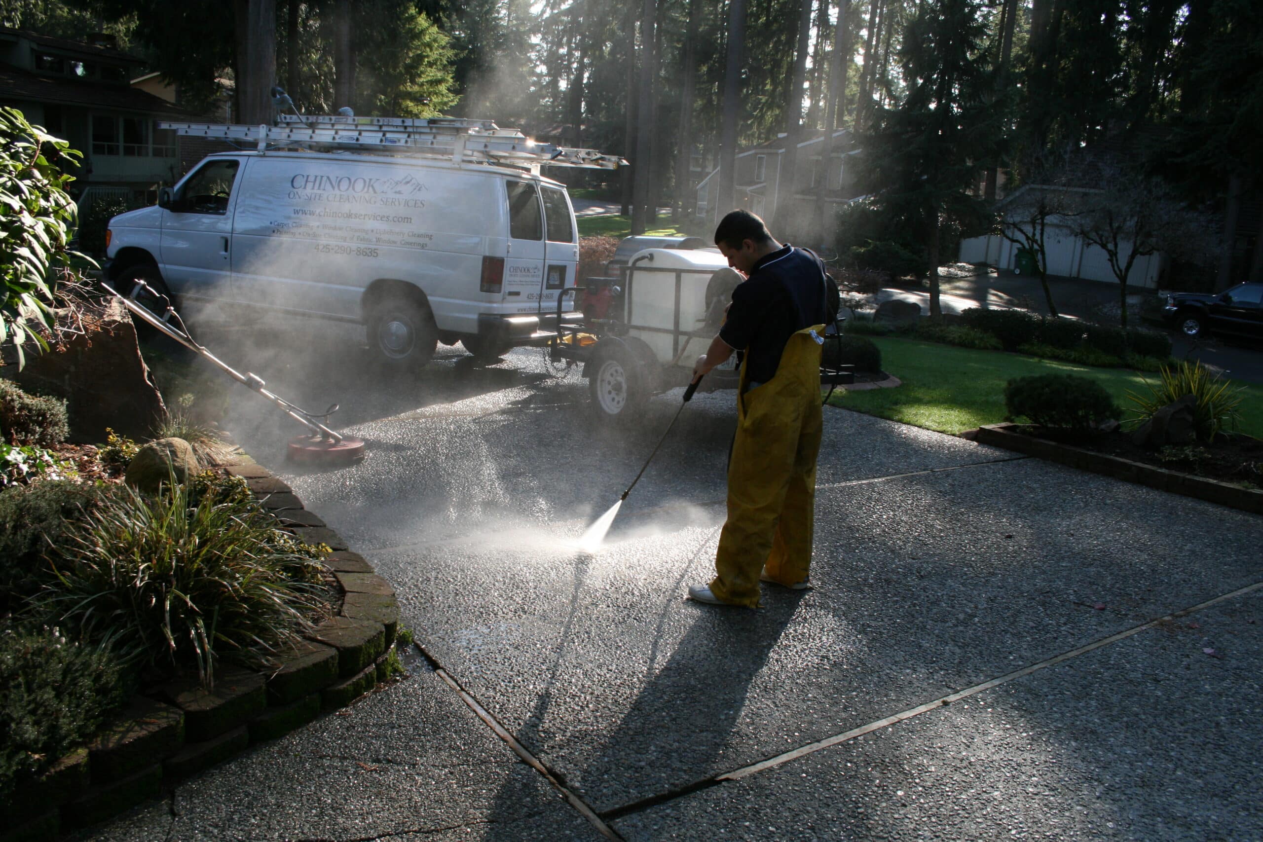 Blasting moss and debris from driveway in Issaquah, WA using pressure washing machine.