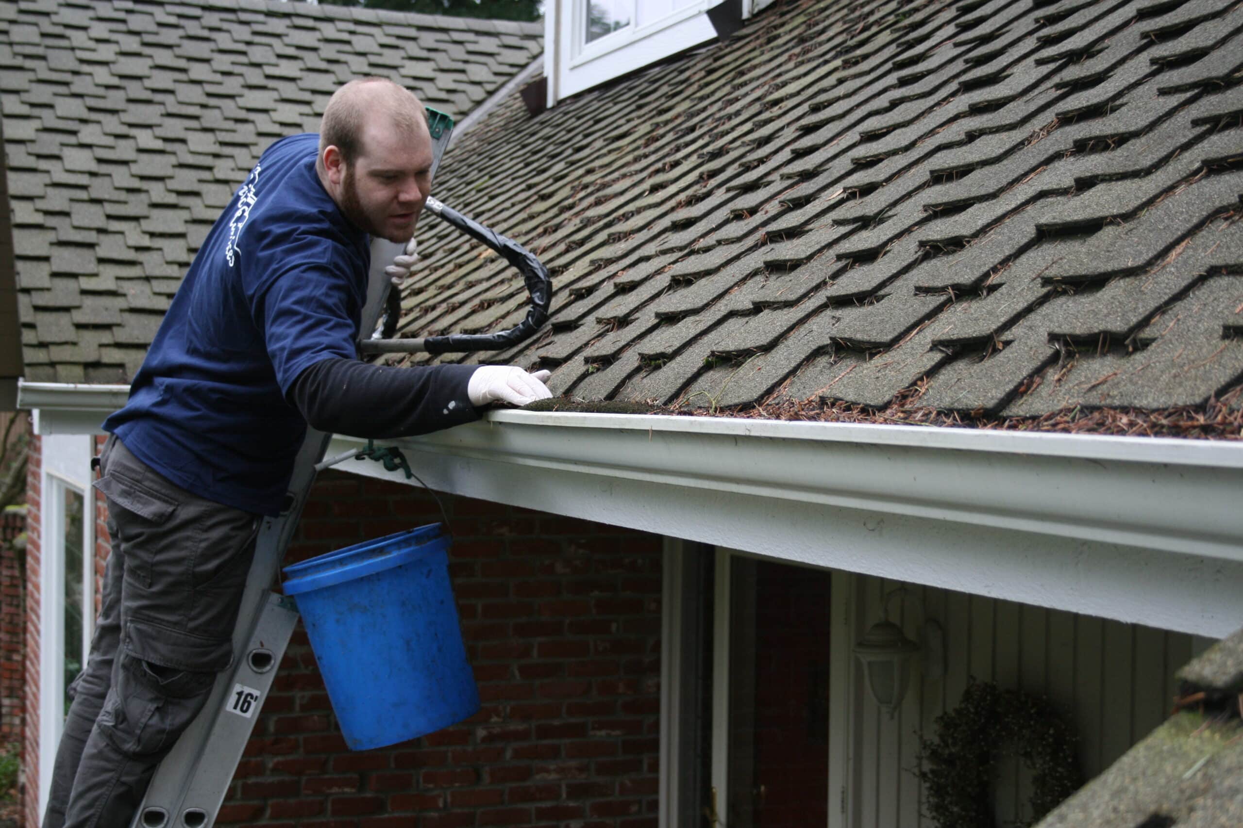 Hand cleaning tall gutters in Mercer Island
