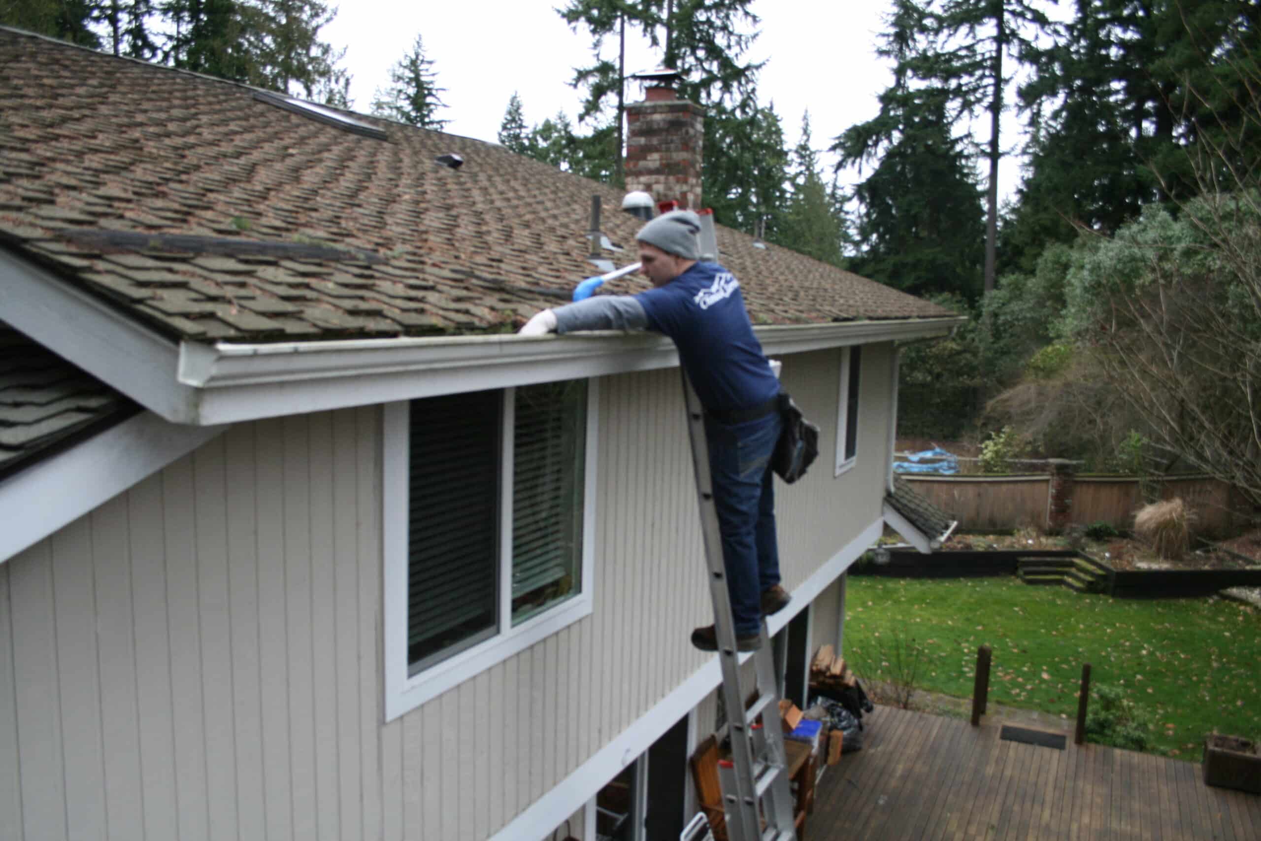 Cleaning gutters in North Creek by hand