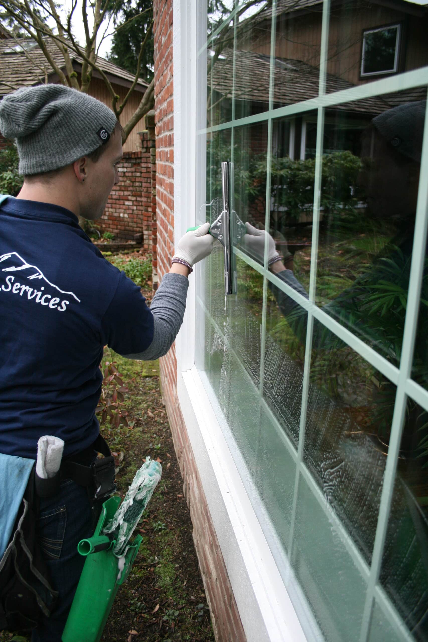 Cleaning a window in North Creek area by Chinook Services