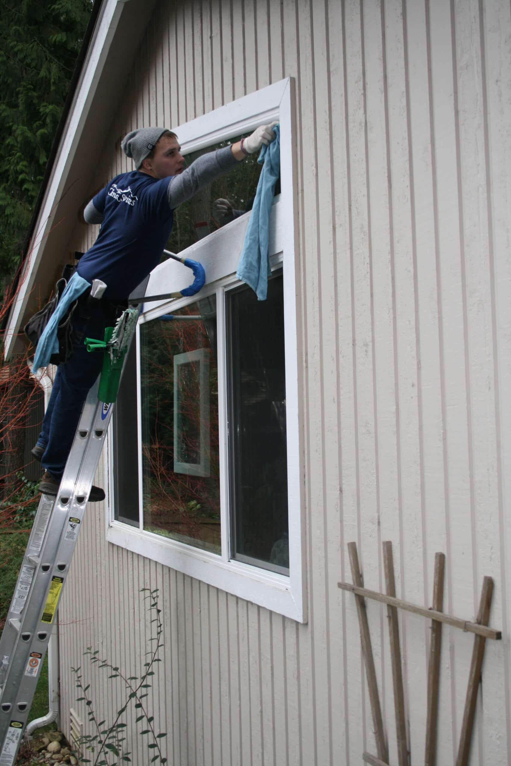 North Creek window cleaning worker hand cleaning from ladder.