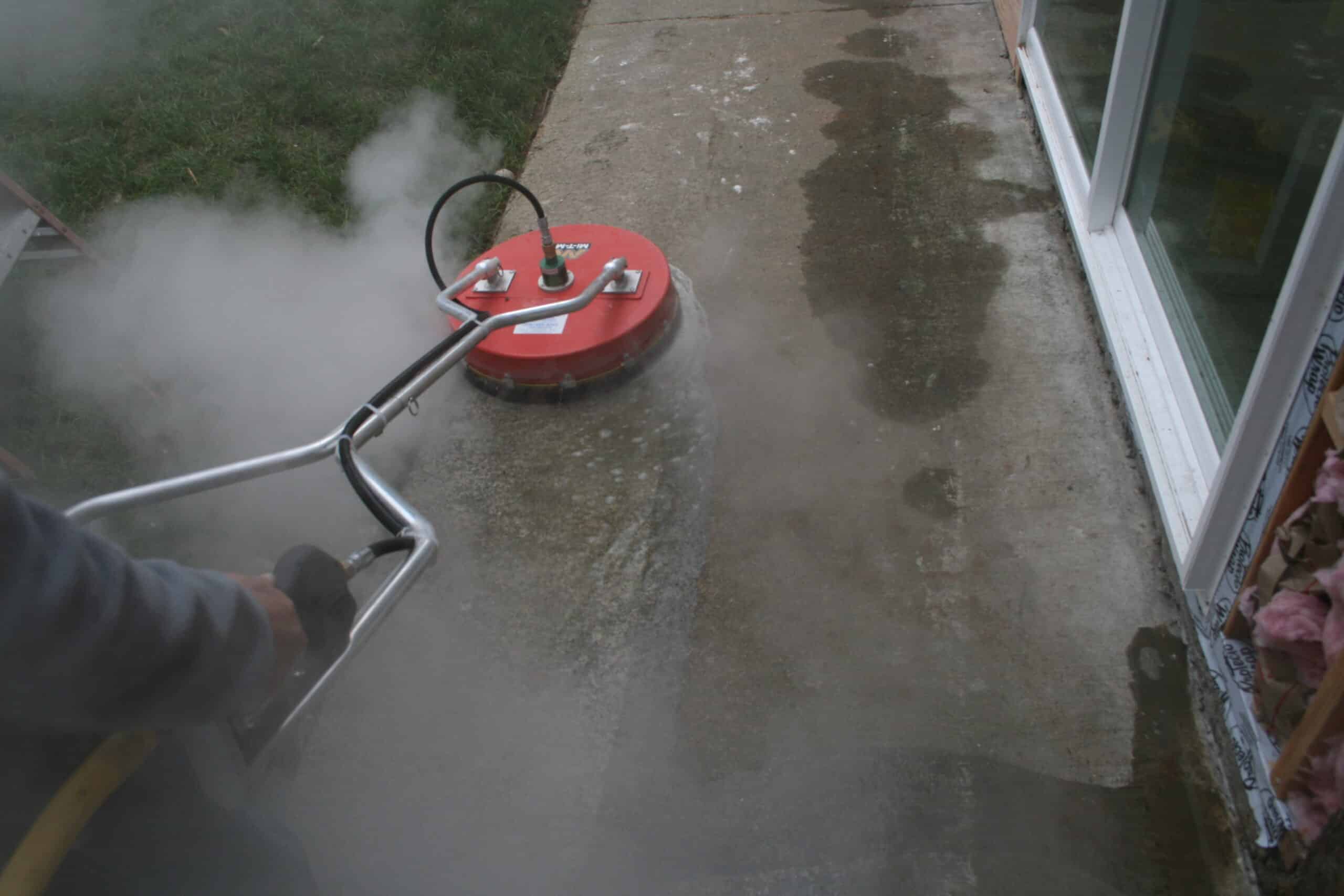 Using surface cleaner to pressure wash concrete walkway in Smokey Point