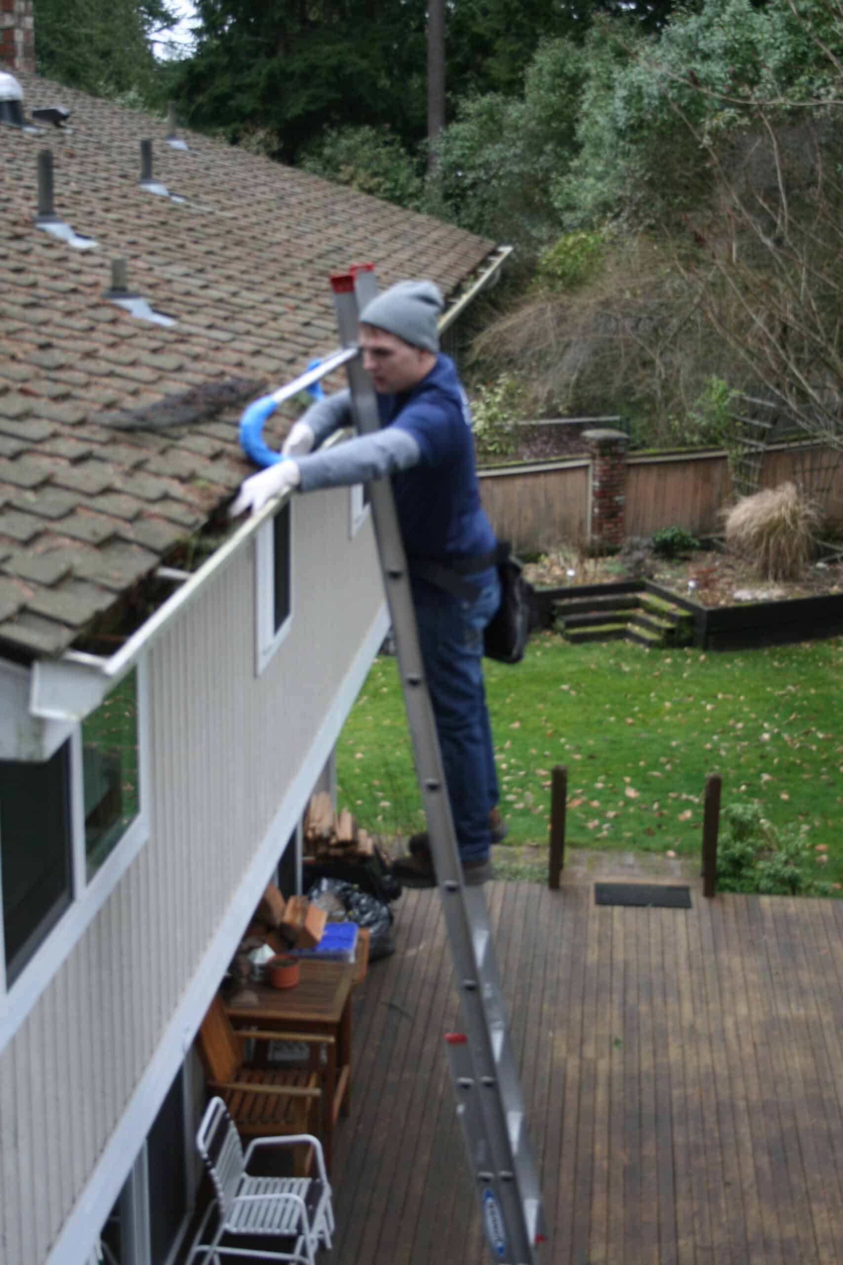 Hand cleaning gutters in Green Lake neighborhood North Seattle.