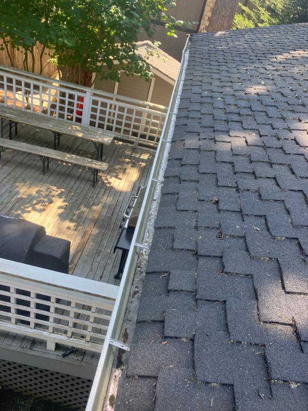 Hand cleaning gutters in Greenwood community