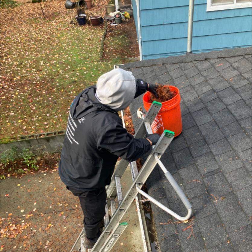 Worker hand cleaning gutter on a home in Everett, WA