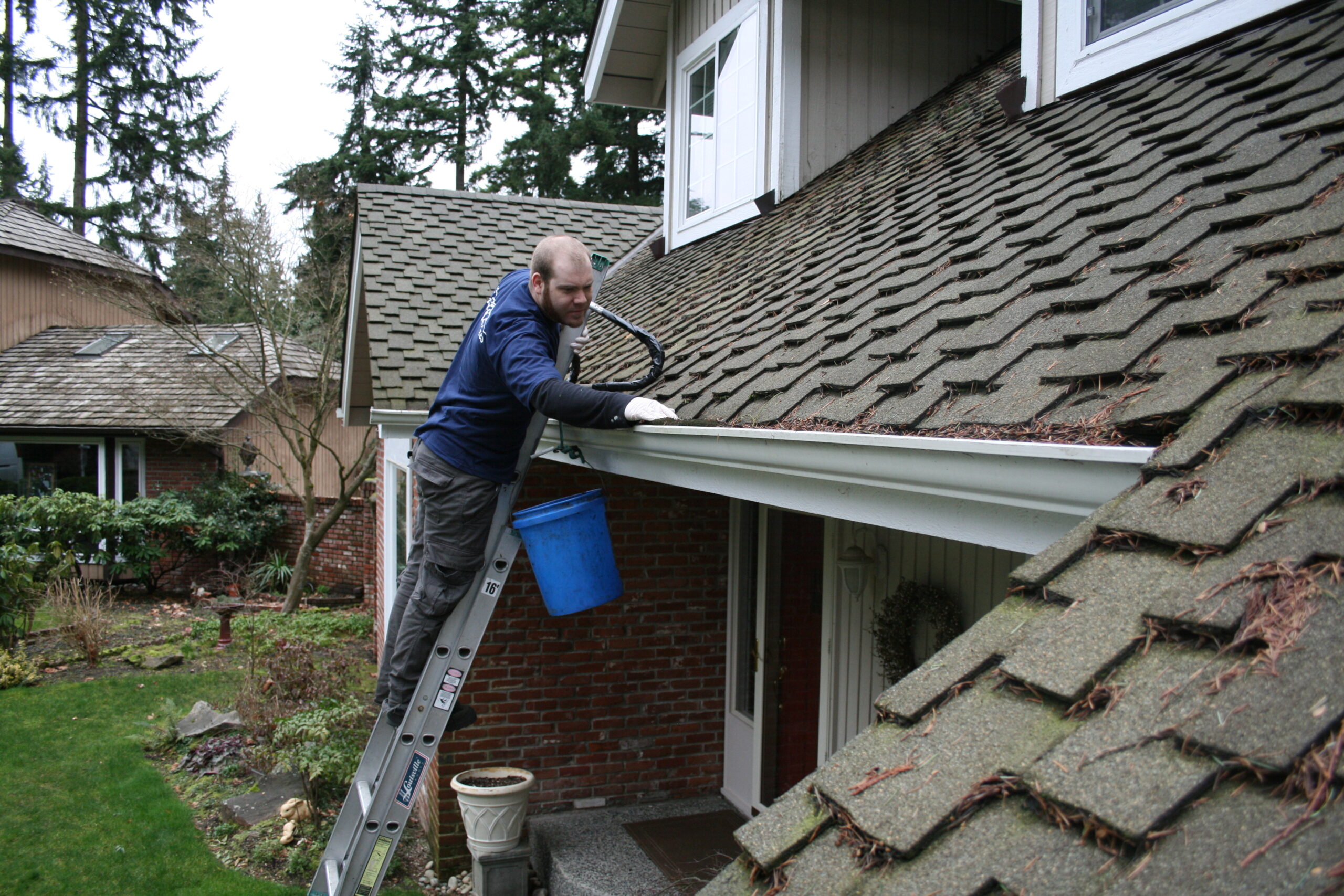 Worker hand cleaning gutters in Seattle